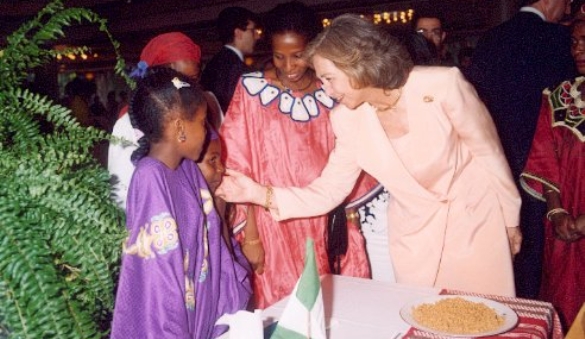 Su Majestad la Reina saludando a unas niñas asistentes al Acto
