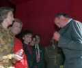 S.M. la Reina se dispone a colocar una banderita a S.M. el Rey durante la cuestación de la Cruz Roja