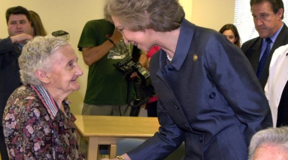 S.M la Reina saluda a una de las ancianas acogidas en el Centro de Atención a Mayores 'Reina Sofia' de la Cruz Roja