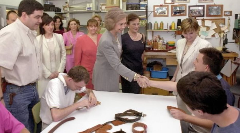 S.M. la Reina, acompañada de la esposa del presidente de Ecuador, saluda a uno de los alumnos del taller de cuero del Centro 'Nuevo Horizonte'