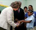 Su Majestad conversa con una niña durante su visita al Colegio Angélica Massé de Santo Domingo