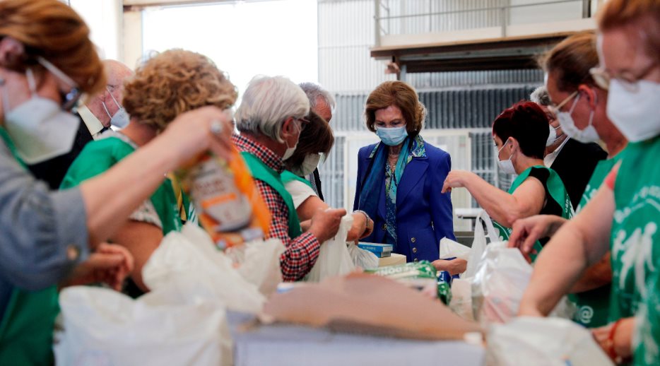 Su Majestad la Reina Doña Sofía junto a los voluntarios que están preparando las bolsas para su reparto