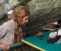 La Reina Sofía observa algunos elementos hallados en la Cueva Mayor